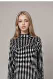 Black and white houndstooth long sleeve top with high neckline and mesh panel