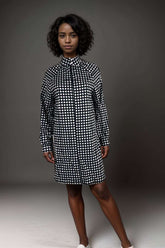 Woman wearing a black and white polka dot long sleeve shirt dress