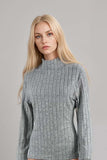 Woman wearing a grey ribbed knit high neck long sleeve top