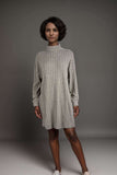Woman wearing a grey ribbed knit sweater dress with high neck and boots