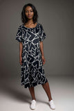 Woman wearing black midi dress with white abstract heart print and flutter sleeves