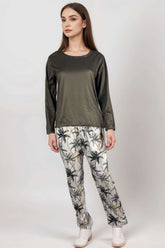 Woman wearing olive satin long-sleeve top and palm tree print lounge trousers