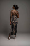 Back view of a woman in a black and gold striped bodycon midi dress, showcasing curves and sleek styling.