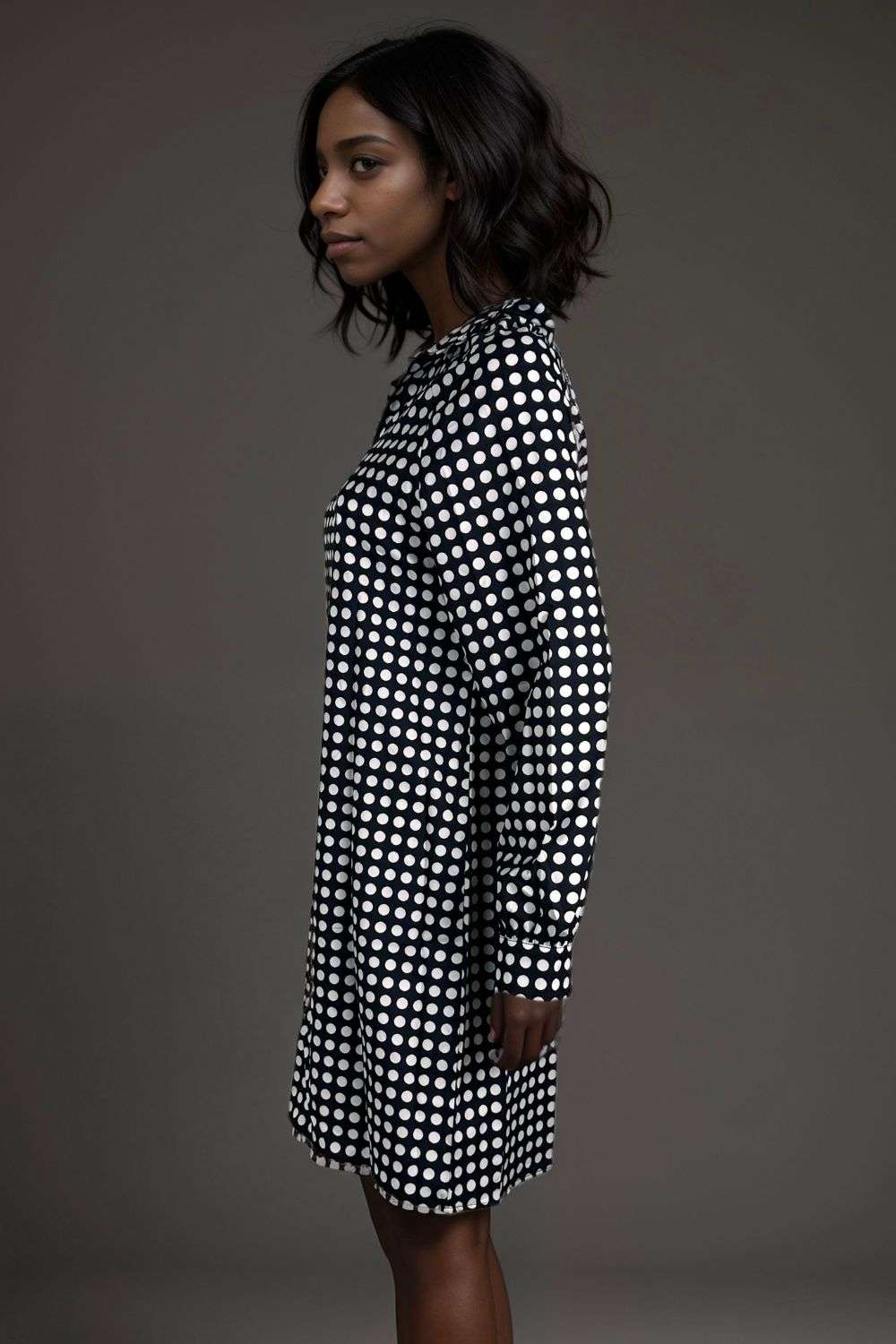 Woman wearing a black and white polka dot long sleeve shirt dress