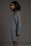 Woman wearing a black and white polka dot long sleeve shirt dress