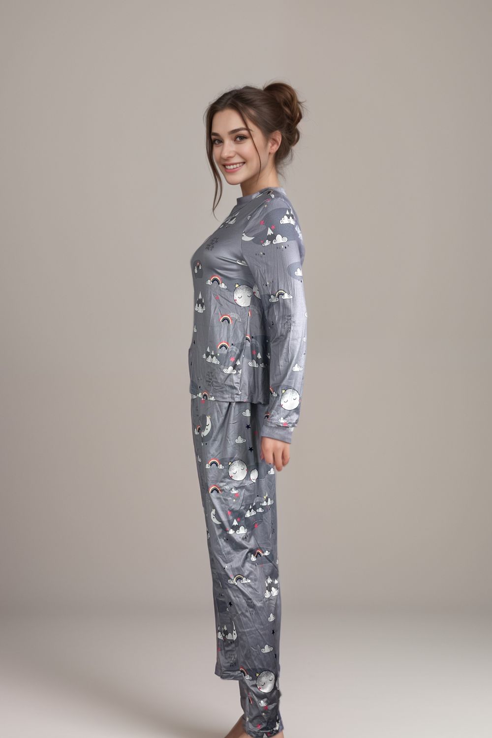 Woman wearing a grey long-sleeve pajama set with cloud and rainbow prints