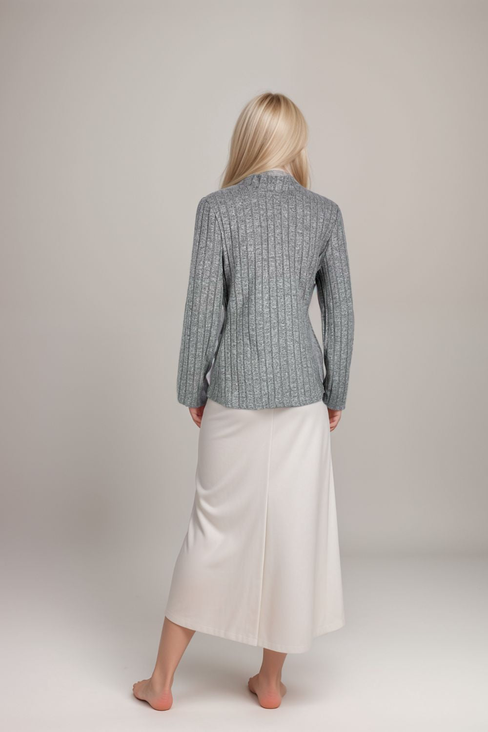 Woman wearing a grey ribbed knit high neck long sleeve top