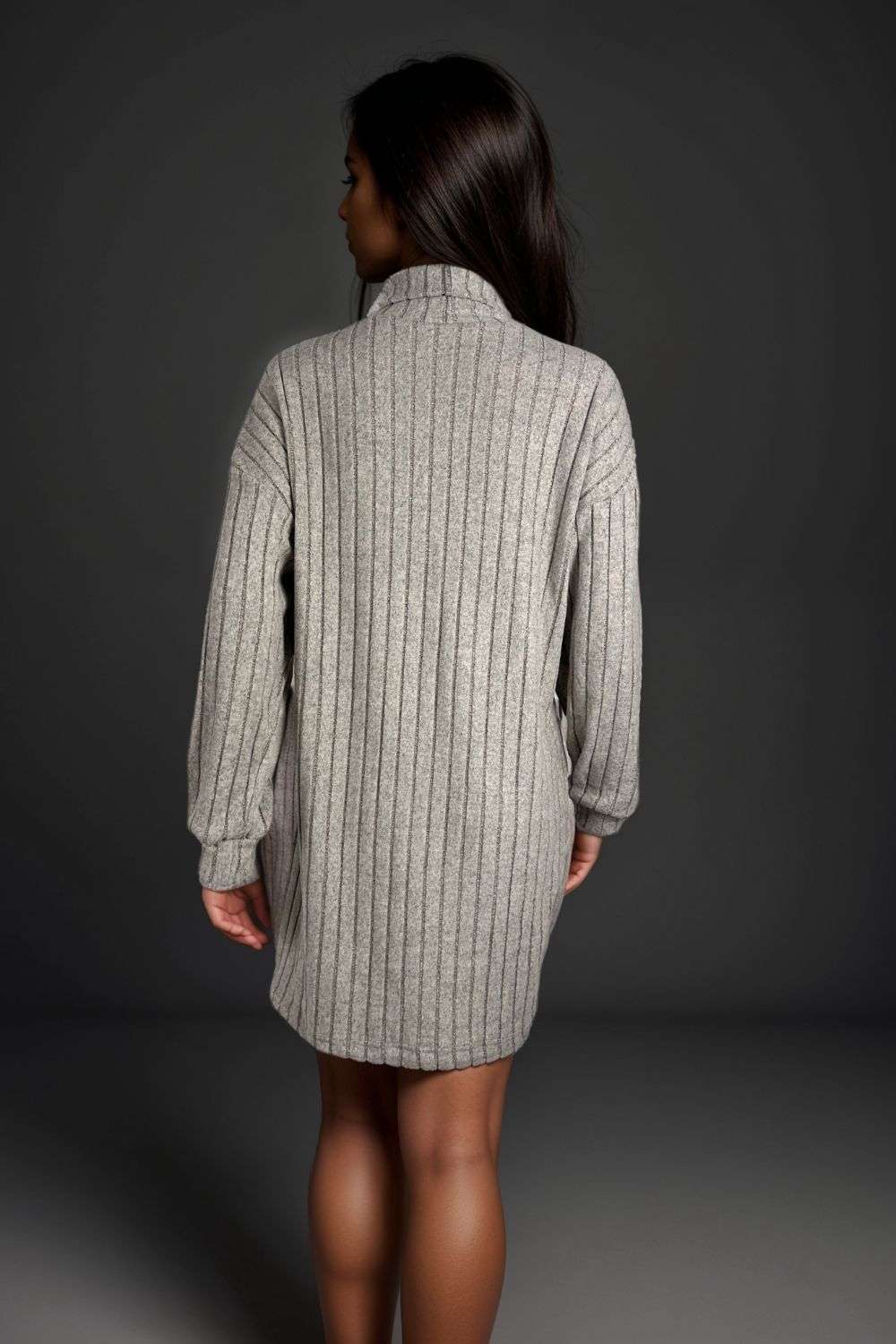 Woman wearing a grey ribbed knit sweater dress with high neck and boots