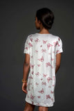 Satin Butterfly Print NightdressWoman wearing a white satin lounge dress with pink butterfly pattern
