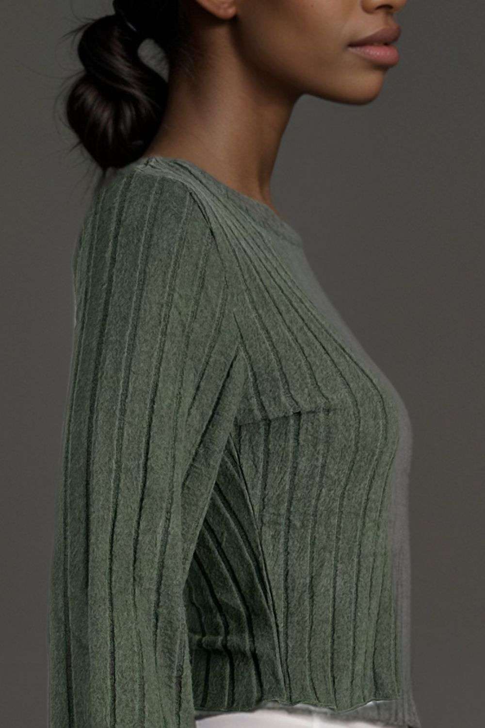 Woman wearing an olive green ribbed knit long sleeve top with white shorts