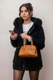 Woman wearing black hooded coat with faux fur trim 