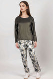 Woman wearing olive satin long-sleeve top and palm tree print lounge trousers
