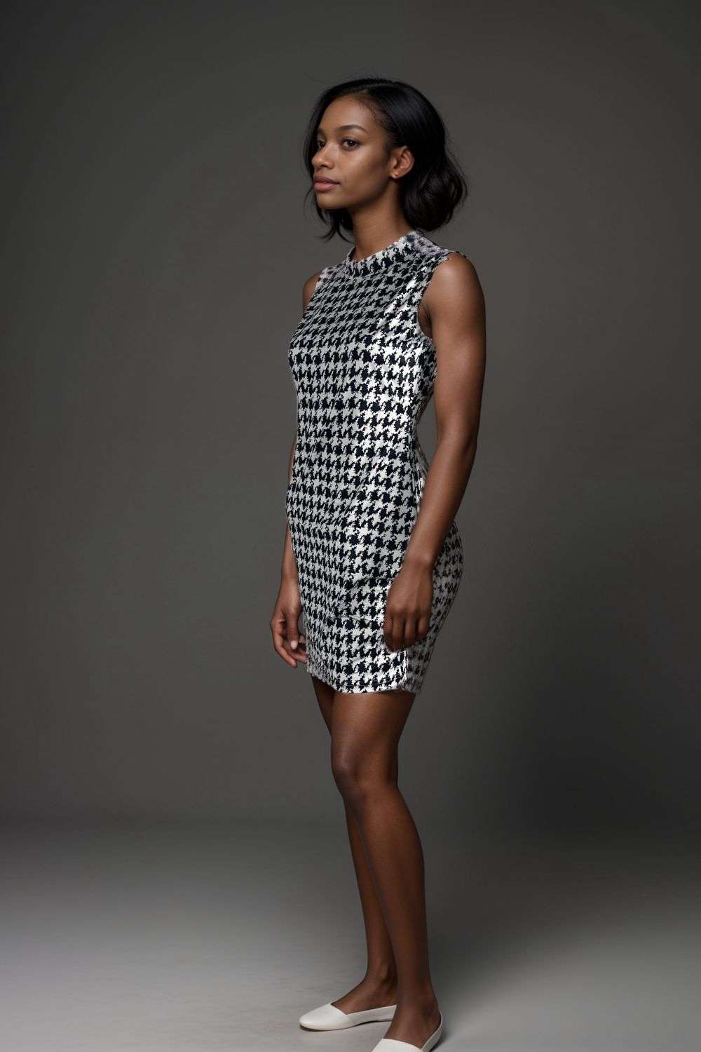 Woman wearing sleeveless black and white houndstooth mini bodycon dress